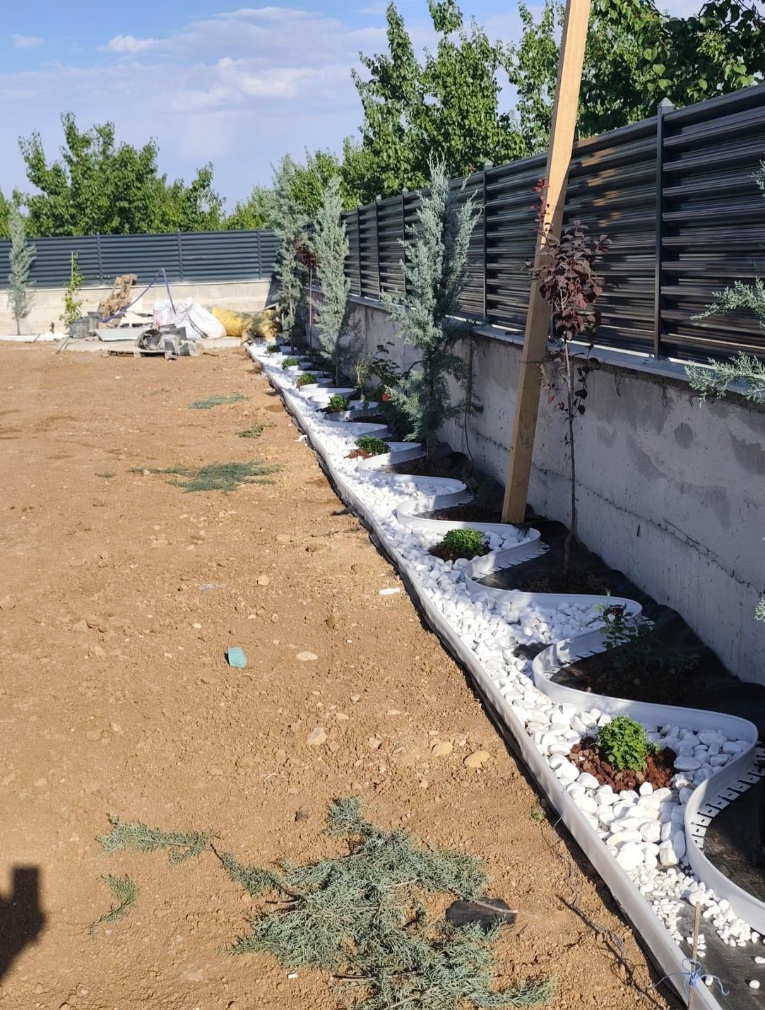 Bahçe çevre duvarı boyunca sürdürülen bordür ve bitkilendirme uygulaması